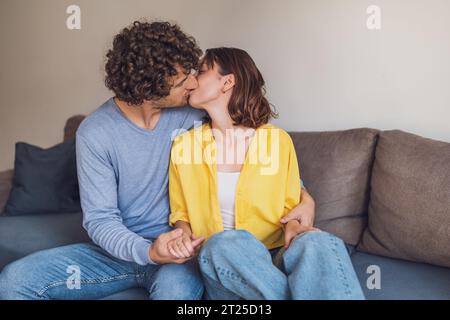 Das junge Paar umschließt und küsst sich zu Hause. Stockfoto
