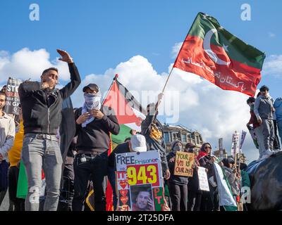 London, Großbritannien. 14. Oktober 2023: Anhänger des pakistanischen Politikers Imran Khan und seiner Partei Pakistan Tehreek-e-Insaf (PTI) schwenken eine Flagge und protestieren mit Pro-Pa Stockfoto