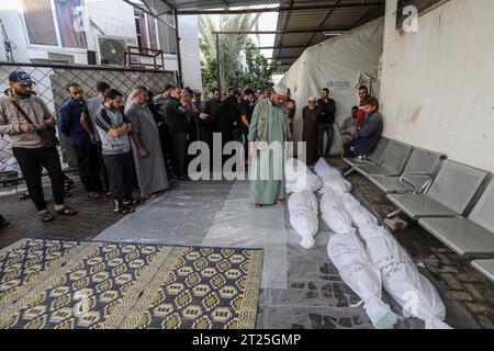 Rafah, Palästinensische Gebiete. Oktober 2023. Die Menschen versammeln sich im Innenhof einer Leichenhalle von den umhüllten Leichen von Palästinensern, die nach einem israelischen Luftangriff auf Rafah im südlichen Gazastreifen getötet wurden. Abed Rahim Khatib/dpa/Alamy Live News Stockfoto