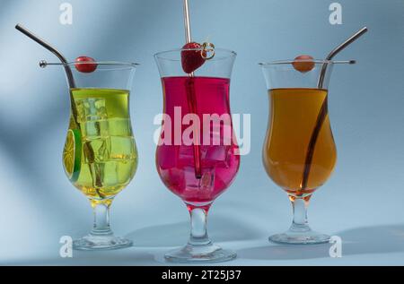 Drei verschiedene Cocktails auf blauem Hintergrund mit Kopierraum Stockfoto