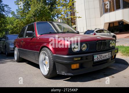 Almaty, Kasachstan - 25. August 2023: Die Front eines alten BMW 3er Coupés ist burgunderrot. Parken auf der Straße Stockfoto