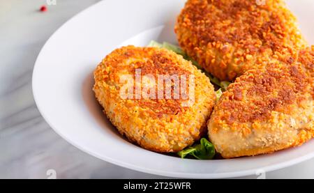 Zwei Hähnchenschnitzel auf einem Blatt Salat, Kartoffelpüree und Tomatensoße. Koteletts nach Kiew-Art Stockfoto