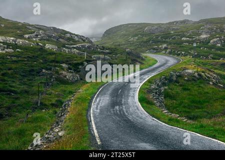 Die Golden Road ist eine malerische einspurige Straße, die sich durch die zerklüftete Landschaft der Isle of Harris schlängelt und einen atemberaubenden Blick auf den Atlantik bietet Stockfoto