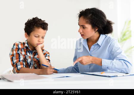 Lehrerin schimpft Schülerjungen im modernen Klassenzimmer Stockfoto