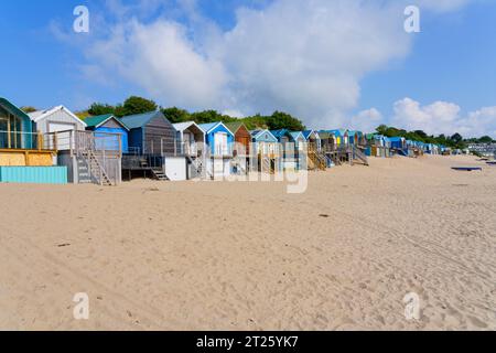 An einem Sommertag haben wir verschiedene bunte Strandhütten entlang des hinteren Teils des Abersoch Strandes. Stockfoto