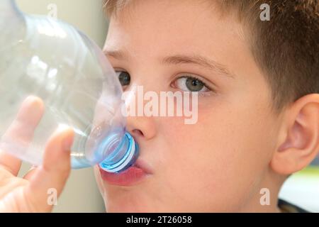 Junge trinkt eine Plastikflasche Wasser Stockfoto