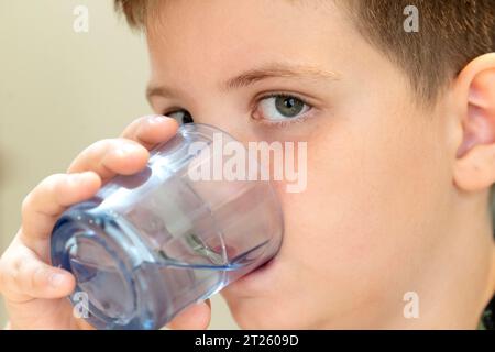 Junge trinkt ein Glas Wasser Stockfoto