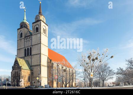 Malerischer Blick auf die alte Johanniskirche in der Altstadt von Magdeburg vor blauem Himmel an kalten, frostigen Wintertagen. Schneebedeckte, sonnige deutsche Stadtlandschaft mit alten Stockfoto