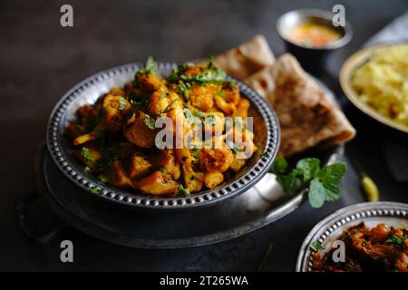 Hausgemachte Aloo Gobi: Indisches vegetarisches Curry mit Kartoffeln und Blumenkohl, serviert mit Reis und Roti Stockfoto