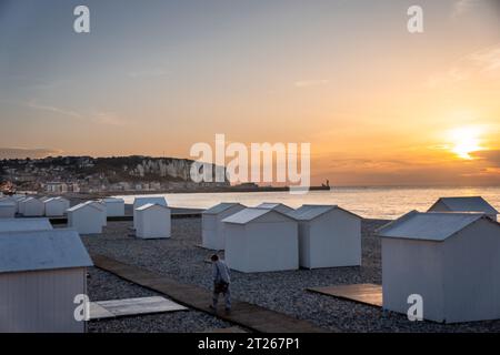 Ein malerischer Sonnenuntergang am Strand mit einer Reihe von Zelten im Vordergrund Stockfoto