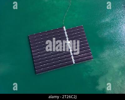 Aus der Vogelperspektive des schwimmenden Solarparks mit vielen Solarpaneelen auf dem türkisfarbenen See Stockfoto