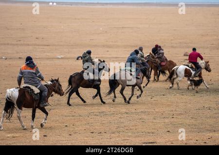 Kok-boru Kirgisistan-Buzkashi Ziegenziehen ist die traditionelle nationale Sportart, in der die Spieler auf den Pferden versuchen, eine Ziege oder ein Kalb zu platzieren Stockfoto