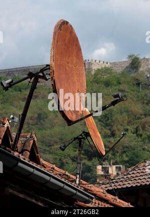 Rostige Satellitenschüsseln auf Dächern in Prizren, Kosovo Stockfoto