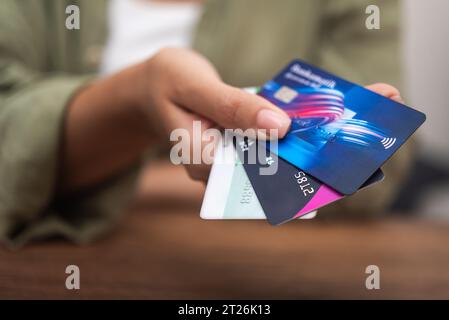 Weibliche Käuferin überreicht mehrere Kreditkarten, um Zahlungen für Waren im Geschäft zu tätigen Stockfoto