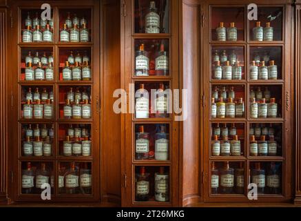 Beaune, Frankreich - 16. August 2023: Apotheke Holzschrank des historischen Krankenhauses in Beaune - Zutaten für die Herstellung von Medikamenten. Flaschen auf der sie Stockfoto