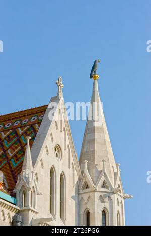 Großaufnahme des Kirchturms Matthias mit schwarzer Rabenskulptur mit vergoldetem Ring im Schnabel, Budapest, Ungarn. Stockfoto