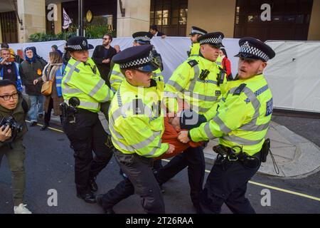 London, Großbritannien. Oktober 2023. Polizeibeamte verhaften einen Klimaprotestantin vor dem InterContinental Hotel in Park Lane während des Energy Intelligence Forum, einem Gipfel der größten Führungskräfte der Ölgesellschaft. Die Demonstranten blockierten den Eingang und versuchten, Delegierte am Betreten des Hotels zu hindern. Quelle: Vuk Valcic/Alamy Live News Stockfoto
