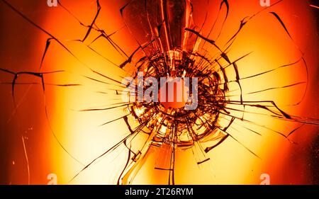 Der zerrissene Schleier: Ein Bullet's Mark auf Glas inmitten eines Inferns Stockfoto