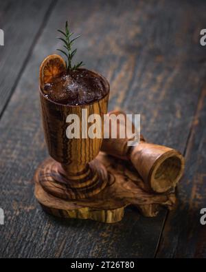 Cocktailglas aus Olivenholz mit Rosmarin Stockfoto