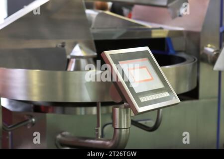 Großaufnahme einer industriellen automatischen Schneidemaschine für die Wurstfleischproduktion. Selektiver Fokus. Stockfoto