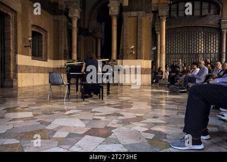 Mantova, Italien - September 2023 - Frau spielt Klavier auf der Veranda eines Palastes, während das Publikum zusieht Stockfoto