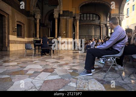 Mantova, Italien - September 2023 - Frau spielt Klavier auf der Veranda eines Palastes, während das Publikum zusieht Stockfoto