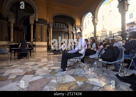 Mantova, Italien - September 2023 - Frau spielt Klavier auf der Veranda eines Palastes, während das Publikum zusieht Stockfoto