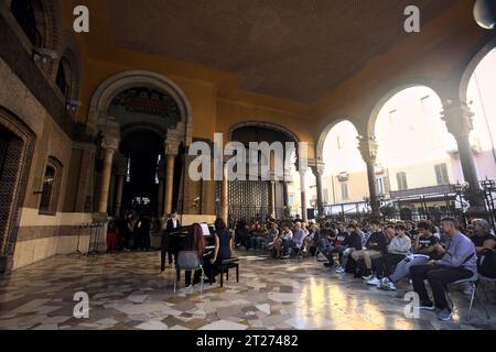 Mantova, Italien - September 2023 - Frau spielt Klavier auf der Veranda eines Palastes, während das Publikum zusieht Stockfoto