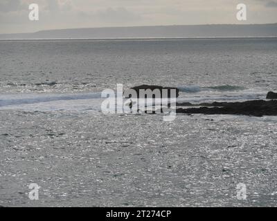 Surfer in abendlicher Stimmung auf den Wellen am Strand von Porthleven in Cornwall England Stockfoto