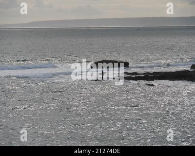 Surfer in abendlicher Stimmung auf den Wellen am Strand von Porthleven in Cornwall England Stockfoto