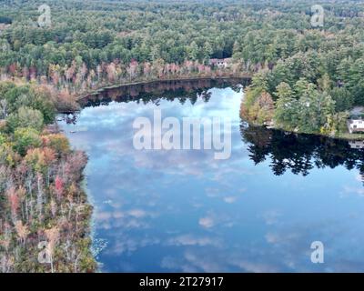 Eine ruhige Landschaft mit einem Fluss mit üppigem Laub auf beiden Seiten, umgeben von einem Wald von hohen Bäumen mit ihren smaragdgrünen Blättern Stockfoto