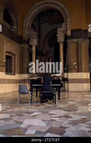 Mantova, Italien - September 2023 - Frau spielt Klavier auf der Veranda eines Palastes, während das Publikum zusieht Stockfoto