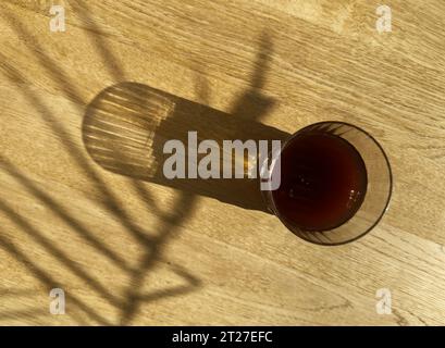 Kaltkaffee, frisches eiskaltes Getränk auf Holztisch an sonnigem Tag, Blick von oben Stockfoto