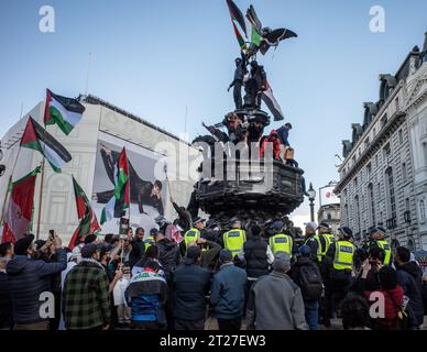 Die Polizei versucht, pro-palästinensische Demonstranten zu entfernen, die während des marsches für Palästina am 14. Oktober den Eros-Brunnen am Piccadilly-Zirkus bestiegen haben. Stockfoto