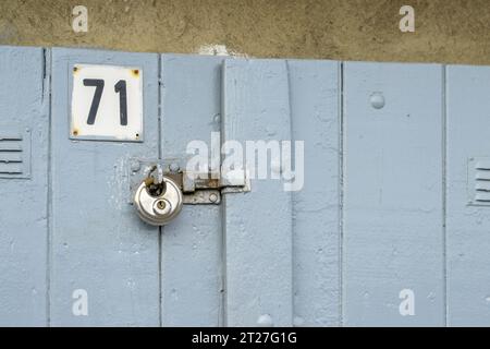 Ein Vorhängeschloss an einer neu bemalten Holztür Stockfoto