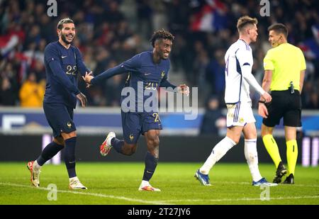 Frankreichs Kingsley Coman (Mitte) feiert mit Teamkollege Theo Hernandez das vierte Tor des Spiels, während Schottlands Scott McTominay (zweiter rechts) während des internationalen Freundschaftsspiels im Stade Pierre Mauroy in Lille, Frankreich, niedergeschlagen aussieht. Bilddatum: Dienstag, 17. Oktober 2023. Stockfoto