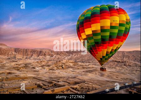 Heißluftballon fliegt über den Tempel des Tuthmosis III. Mortuary und den Tempel der Hatschepsut am Fuße der Klippen von Deir el-Bahari im Hintergrund Stockfoto