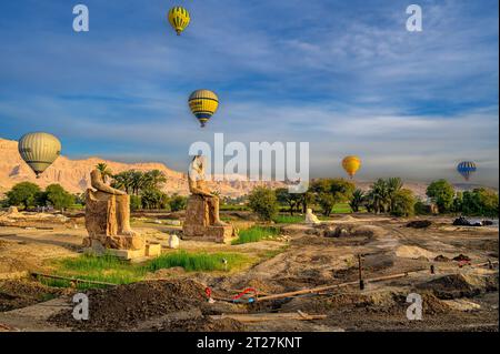 Heißluftballons fliegen über die Statuen der kolosse von KOM El Hitan in der Nähe des zweiten Pylons des Totentempels von Amenhotep III Stockfoto