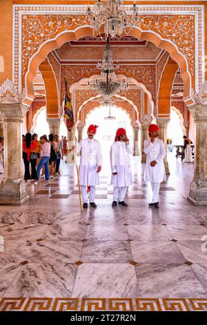 Die Palastwächter, gekleidet in traditionellen Uniformen, stehen in den Diwan-i-Khas im Stadtpalast in Jaipur, Rajasthan, Indien Stockfoto