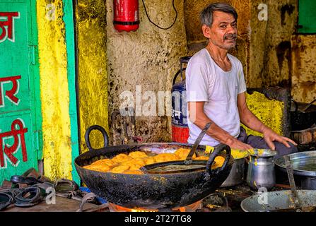 Straßenverkäufer an der alten Uhrenturmstraße in Jodhpur, der Aloo vada, das beliebte indische Street Food, kocht Stockfoto