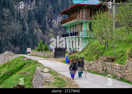 Zwei Dorfbewohner, die am Durga Homestay vorbeilaufen, auf dem Weg zum Dorf Sharchi in Himachal Pradesh Stockfoto