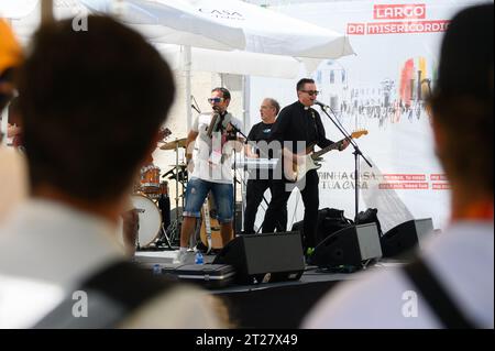 Eine Band, darunter ein katholischer Priester, gab ein Konzert während der Weltjugendtage 2023 in Lissabon, Portugal. Das Konzert fand in der Nähe der St. roch Kirche statt. Stockfoto