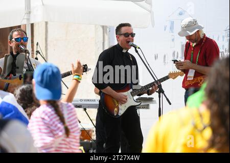 Eine Band, darunter ein katholischer Priester, gab ein Konzert während der Weltjugendtage 2023 in Lissabon, Portugal. Das Konzert fand in der Nähe der St. roch Kirche statt. Stockfoto