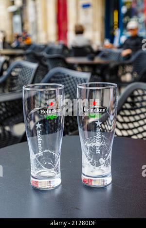 Zwei leere Biergläser mit Heineken-Emblem auf einem Tisch in einer Café-Bar in Bordeaux, einer Hafenstadt an der Garonne im Südwesten Frankreichs Stockfoto