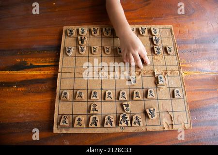 Holzbrett des japanischen Schachs oder Shogi-Brettspiel auf Holztisch für Kinder Kinderspieler, die im Wettkampf im Wat Khao DIN Tempel in Suphan spielen Stockfoto