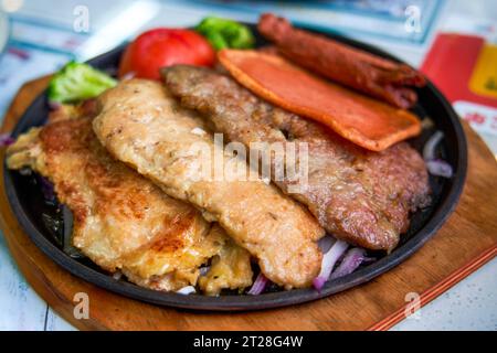 Ein köstliches und verführerisches, brutzelndes Steak, Huhn und Schweinekotelett in einem Teestaurant im Hong Kong-Stil Stockfoto