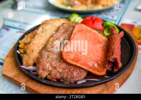 Ein köstliches und verführerisches, brutzelndes Steak, Huhn und Schweinekotelett in einem Teestaurant im Hong Kong-Stil Stockfoto