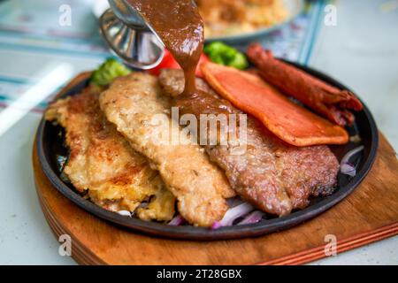 Ein köstliches und verführerisches, brutzelndes Steak, Huhn und Schweinekotelett in einem Teestaurant im Hong Kong-Stil Stockfoto