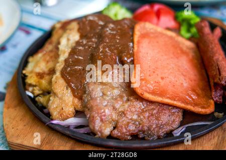 Ein köstliches und verführerisches, brutzelndes Steak, Huhn und Schweinekotelett in einem Teestaurant im Hong Kong-Stil Stockfoto