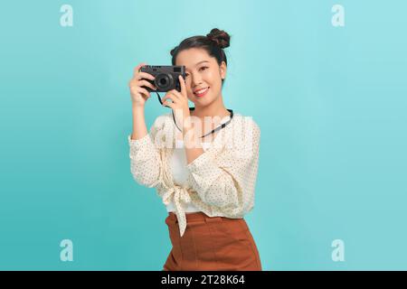 Vollständiges isoliertes Studiobild einer jungen und schönen Frau mit Retro-Kamera Stockfoto